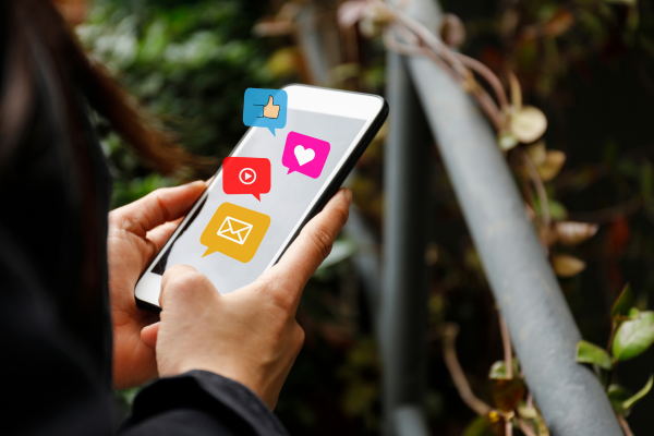 person on phone with social media icons popping out